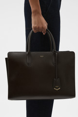 Profile view of model wearing the Oroton Muse 15" Worker Tote in Dark Chocolate and Saffiano leather exterior for Women .