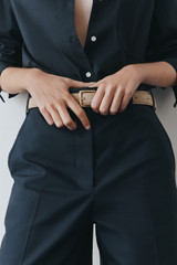 Profile view of model wearing the Oroton Remi 25MM Suede Belt in Caper and Premium textured leather material for Women .
