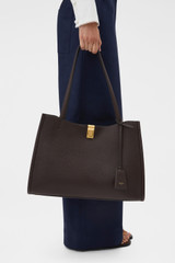 Profile view of model wearing the Oroton Mille Work Tote in Dark Chocolate and Premium pebble leather for Women .