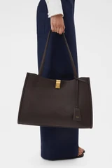 Profile view of model wearing the Oroton Mille Work Tote in Dark Chocolate and Premium pebble leather for Women .