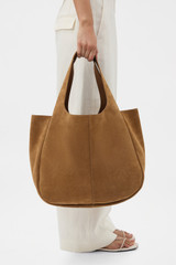 Profile view of model wearing the Oroton Emilia Suede Large Tote in Teak and Premium suede leather for Women .