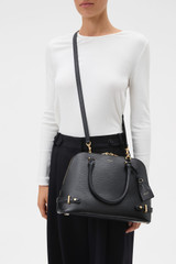 Profile view of model wearing the Oroton Grace Grip Top in Black and Premium Saffiano leather body for Women .