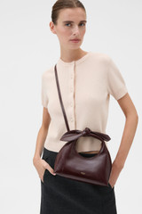 Profile view of model wearing the Oroton Myrtle Crackle Mini Bag in Copper and Premium crackle leather for Women .