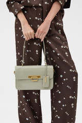 Profile view of model wearing the Oroton Finn Crackle Large Day Bag in Pistachio and Premium smooth leather for Women .