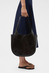 Profile view of model wearing the Oroton Emilia Crackle Tote in Dark Chocolate and Premium crackle leather for Women .