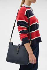 Profile view of model wearing the Oroton Dylan Large Bucket in Dark Navy and Premium pebble leather for Women .