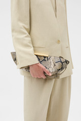 Profile view of model wearing the Oroton Miriam Clutch in Taupe/Black and Premium embossed leather for Women .