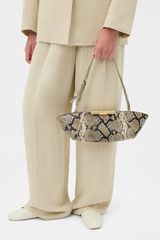 Profile view of model wearing the Oroton Miriam Clutch in Taupe/Black and Premium embossed leather for Women .