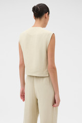 Profile view of model wearing the Oroton Button Detail Vest in Almond Creme and 72% Viscose, 28% linen for Women .