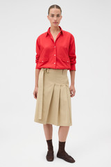 Profile view of model wearing the Oroton Pleat Detail Midi Skirt in Sable and 100% cotton fabric for Women .