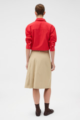Profile view of model wearing the Oroton Pleat Detail Midi Skirt in Sable and 100% cotton fabric for Women .