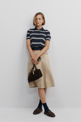 Profile view of model wearing the Oroton Pleat Detail Midi Skirt in Sable and 100% cotton fabric for Women .