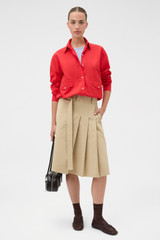 Profile view of model wearing the Oroton Pleat Detail Midi Skirt in Sable and 100% cotton fabric for Women .