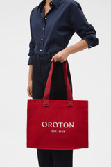 Profile view of model wearing the Oroton Everyday Tote in Dark Ruby and Crafted from 99.9% recycled polyester material for Women .