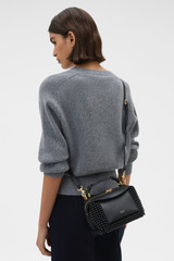 Profile view of model wearing the Oroton Mica Beaded Mini Bowler in Black and Premium canvas material for Women .