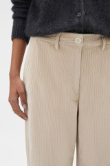 Profile view of model wearing the Oroton Fine Corduroy Pant in Eggshell and 97% cotton and 3% spandex blend fabric for Women .