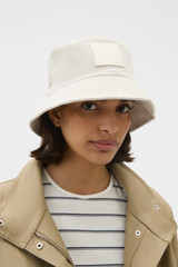 Profile view of model wearing the Oroton Corduroy Bucket Hat in Eggshell and 100% cotton fabric for Women .