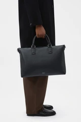 Profile view of model wearing the Oroton Paxton Briefcase in Black and Premium pebble leather for Men .
