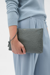 Profile view of model wearing the Oroton Marais Texture Wristlet Pouch in Soot and Premium embossed leather for Women .
