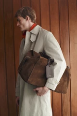 Profile view of model wearing the Oroton Paxton Suede Weekender in Husk Brown and Premium Grade A velvet-finish cow suede leather for Men .