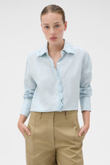 Profile view of model wearing the Oroton Lace Trim Shirt in Soft Smoke Blue and 100% linen fabric for Women .