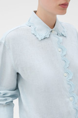 Profile view of model wearing the Oroton Lace Trim Shirt in Soft Smoke Blue and 100% linen fabric for Women .