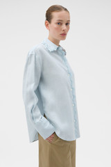 Profile view of model wearing the Oroton Lace Trim Shirt in Soft Smoke Blue and 100% linen fabric for Women .
