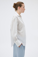 Profile view of model wearing the Oroton Fluid Stripe Shirt in Milk and 57% rayon, 25% polyester, and 18% nylon blend fabri for Women .