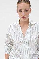 Profile view of model wearing the Oroton Fluid Stripe Shirt in Milk and 57% rayon, 25% polyester, and 18% nylon blend fabri for Women .