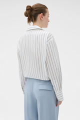 Profile view of model wearing the Oroton Fluid Stripe Shirt in Milk and 57% rayon, 25% polyester, and 18% nylon blend fabri for Women .