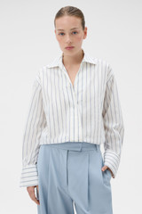 Profile view of model wearing the Oroton Fluid Stripe Shirt in Milk and 57% rayon, 25% polyester, and 18% nylon blend fabri for Women .