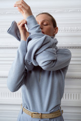 Profile view of model wearing the Oroton Long Sleeve Zip Polo in Twilight Blue and 100% mid-gauge merino wool fabric for Women .