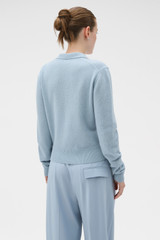 Profile view of model wearing the Oroton Long Sleeve Zip Polo in Twilight Blue and 100% mid-gauge merino wool fabric for Women .