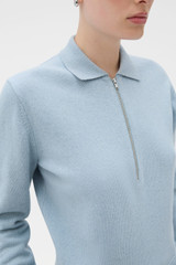 Profile view of model wearing the Oroton Long Sleeve Zip Polo in Twilight Blue and 100% mid-gauge merino wool fabric for Women .