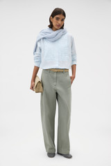 Profile view of model wearing the Oroton Washed Pleated Shirt in Soft Blue and 100% soft cotton fabric for Women .