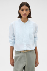 Profile view of model wearing the Oroton Washed Pleated Shirt in Soft Blue and 100% soft cotton fabric for Women .