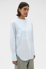 Profile view of model wearing the Oroton Washed Pleated Shirt in Soft Blue and 100% soft cotton fabric for Women .