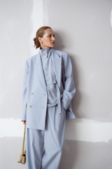 Profile view of model wearing the Oroton Double Breasted Blazer in Twilight Blue and 95% wool and 5% Lycra blend fabri for Women .