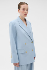 Profile view of model wearing the Oroton Double Breasted Blazer in Twilight Blue and 95% wool and 5% Lycra blend fabri for Women .