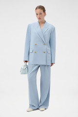 Profile view of model wearing the Oroton Double Breasted Blazer in Twilight Blue and 95% wool and 5% Lycra blend fabri for Women .