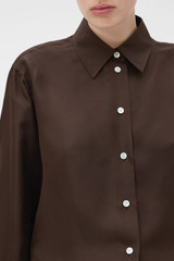 Profile view of model wearing the Oroton Long Sleeve Shirt in Dark Chocolate and 100% silk fabric for Women .