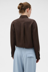 Profile view of model wearing the Oroton Long Sleeve Shirt in Dark Chocolate and 100% silk fabric for Women .