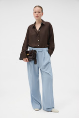 Profile view of model wearing the Oroton Long Sleeve Shirt in Dark Chocolate and 100% silk fabric for Women .