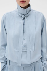 Profile view of model wearing the Oroton Half Placket Button Shirt in Twilight Blue and 100% Fuji silk fabric for Women .