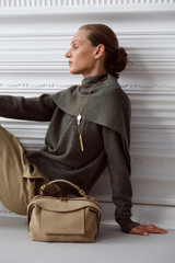Profile view of model wearing the Oroton Wrap Scarf Knit in Soft Khaki and 100% mid-gauge merino wool fabric for Women .