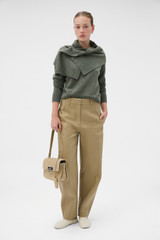 Profile view of model wearing the Oroton Wrap Scarf Knit in Soft Khaki and 100% mid-gauge merino wool fabric for Women .