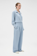 Profile view of model wearing the Oroton Pleat Detail Pant in Twilight Blue and 95% wool and 5% Lycra blend fabri for Women .