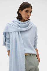Profile view of model wearing the Oroton Cashmere Blend Scarf in Soft Blue and 70% ultra fine merino wool and 30% cashmere blend fabric for Women .