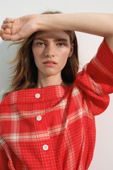 Profile view of model wearing the Oroton Vintage Check Tunic Dress in Ribbon Red and 100% midweight linen fabric for Women .