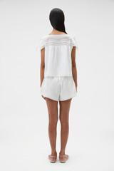 Profile view of model wearing the Oroton Lace Trim Short in White and 100% ramie fabric for Women .
